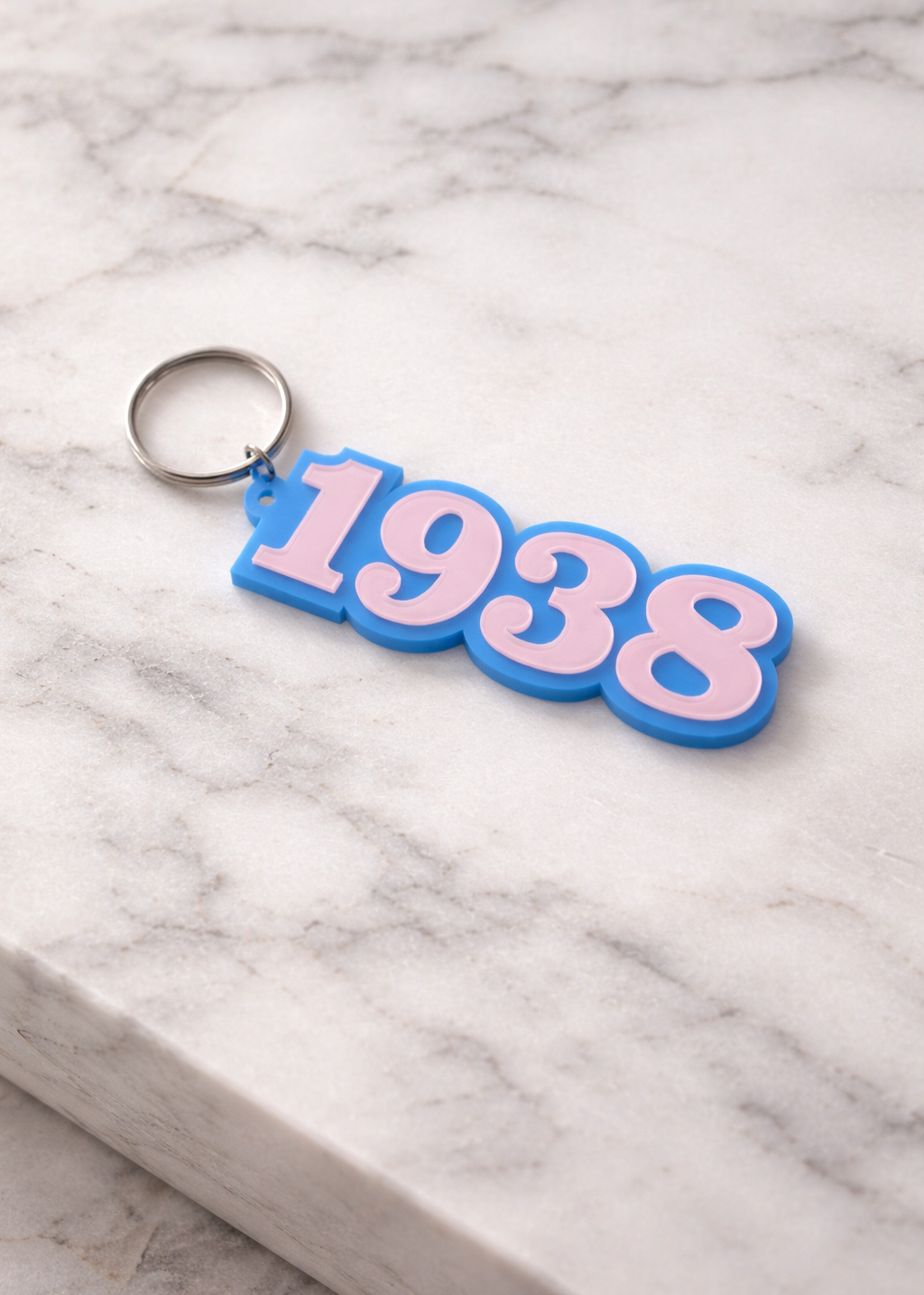 jack and jill of america Keychain with '1938' on a marble surface