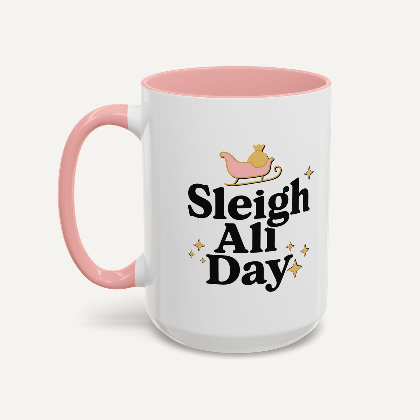 White mug with pink handle and interior, featuring 'Sleigh All Day' text and a sleigh graphic on a white background.