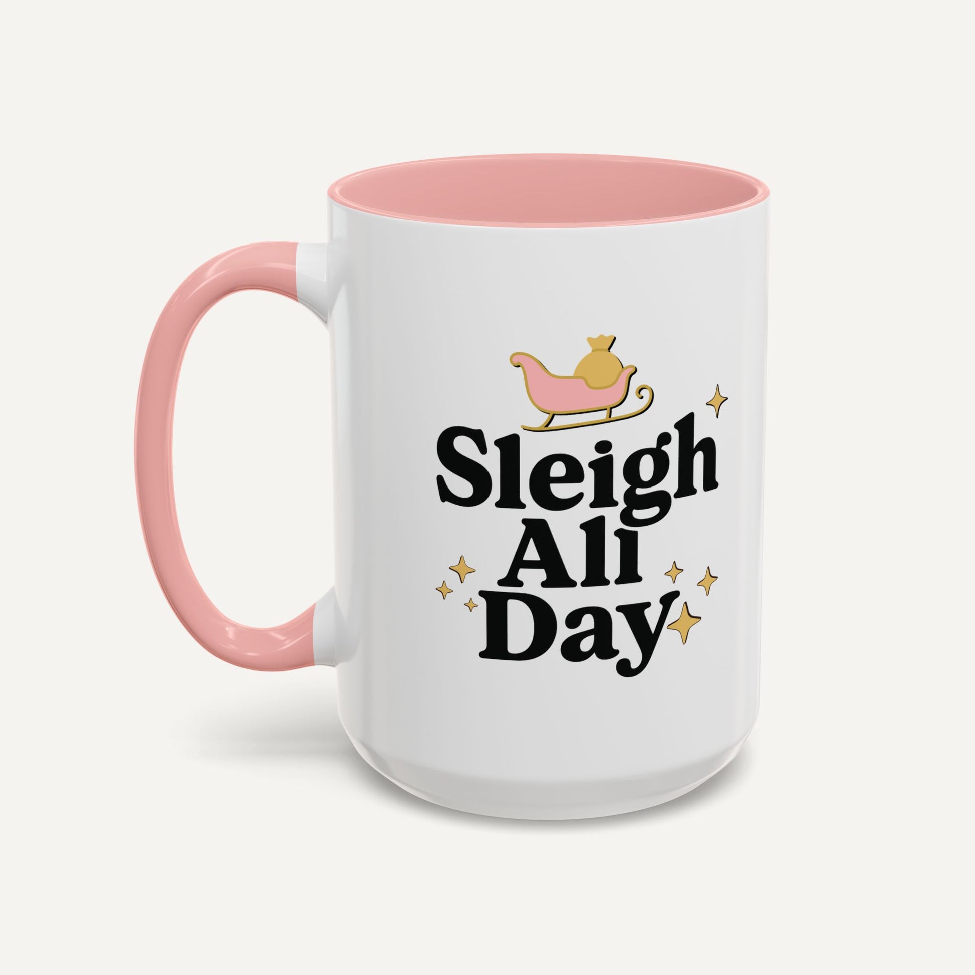 White mug with pink handle and interior, featuring 'Sleigh All Day' text and a sleigh graphic on a white background.