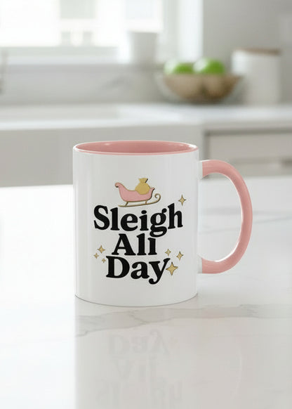 White mug with pink interior and handle featuring 'Sleigh All Day' text and sleigh graphic.