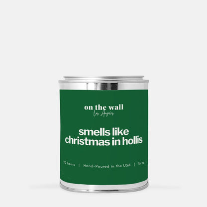 Green candle label with silver lid labeled ' smells like christmas in hollis' on a white background